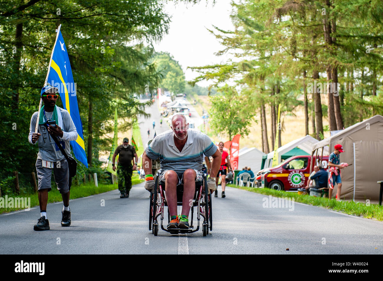 A male participant in a wheelchair climbs a steep slope during the