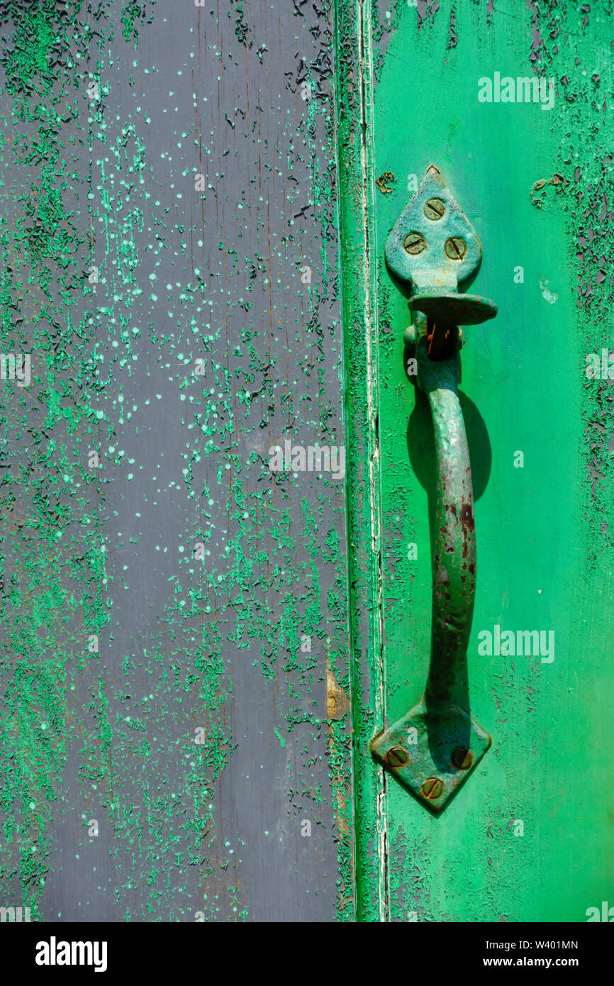 Distressed green painted door with old fashioned handle Stock Photo