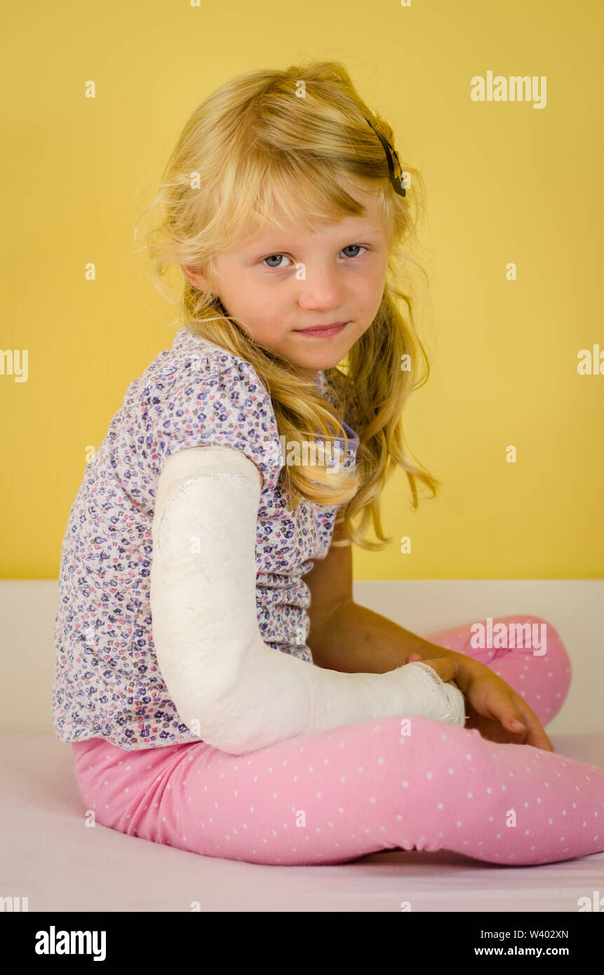 hurt blond kid with broken hand in bandage Stock Photo