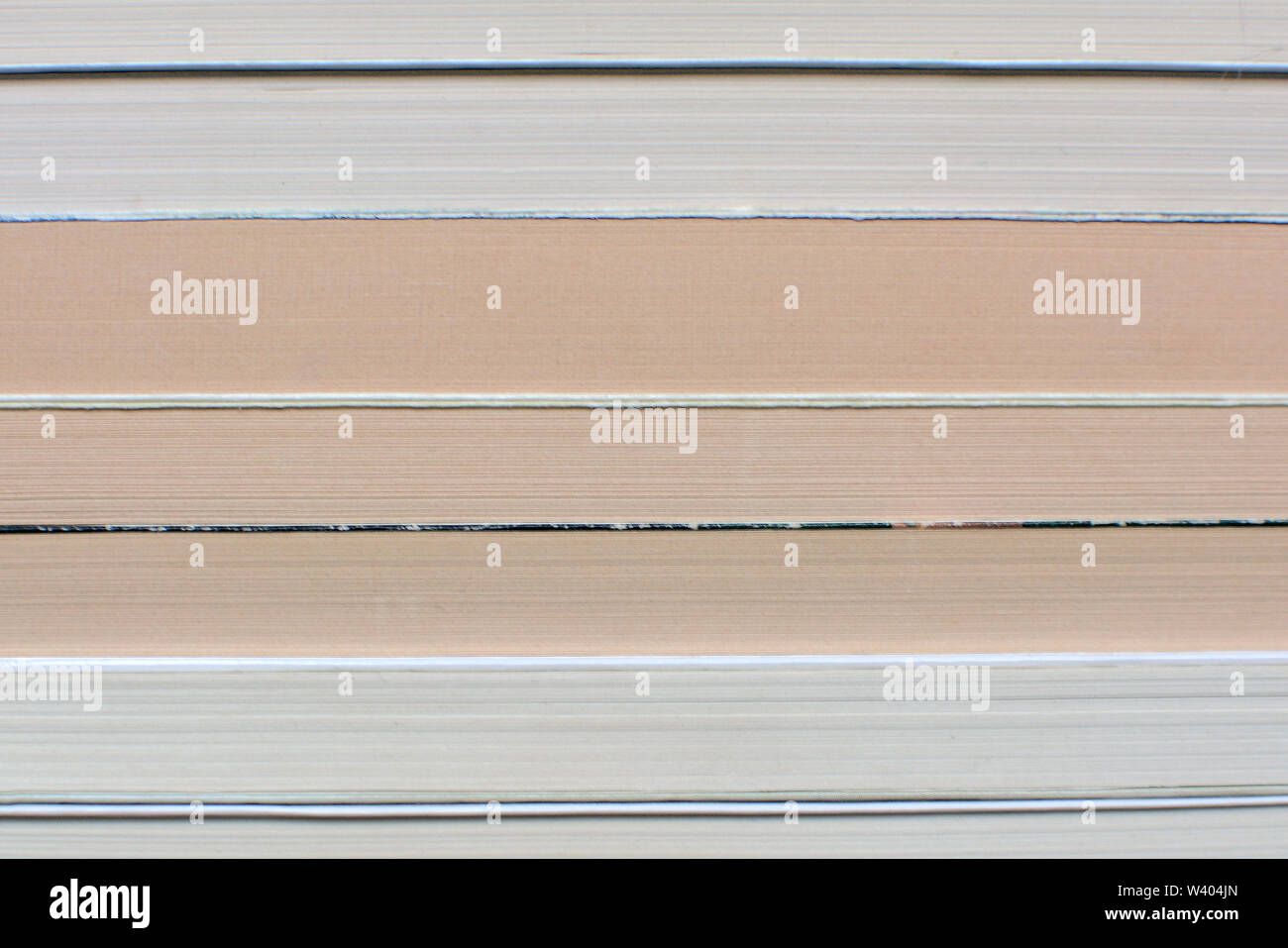 Side view of multiple old and yellowed stacked books background Stock Photo