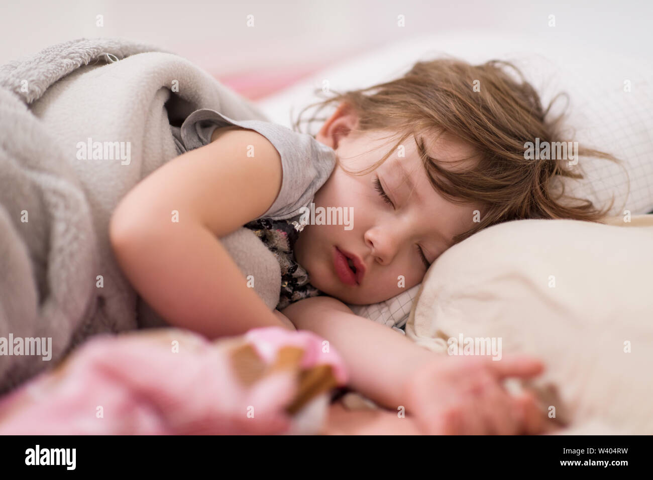 Sweet little girl covered with a blanket sleeping in bed at home Stock ...