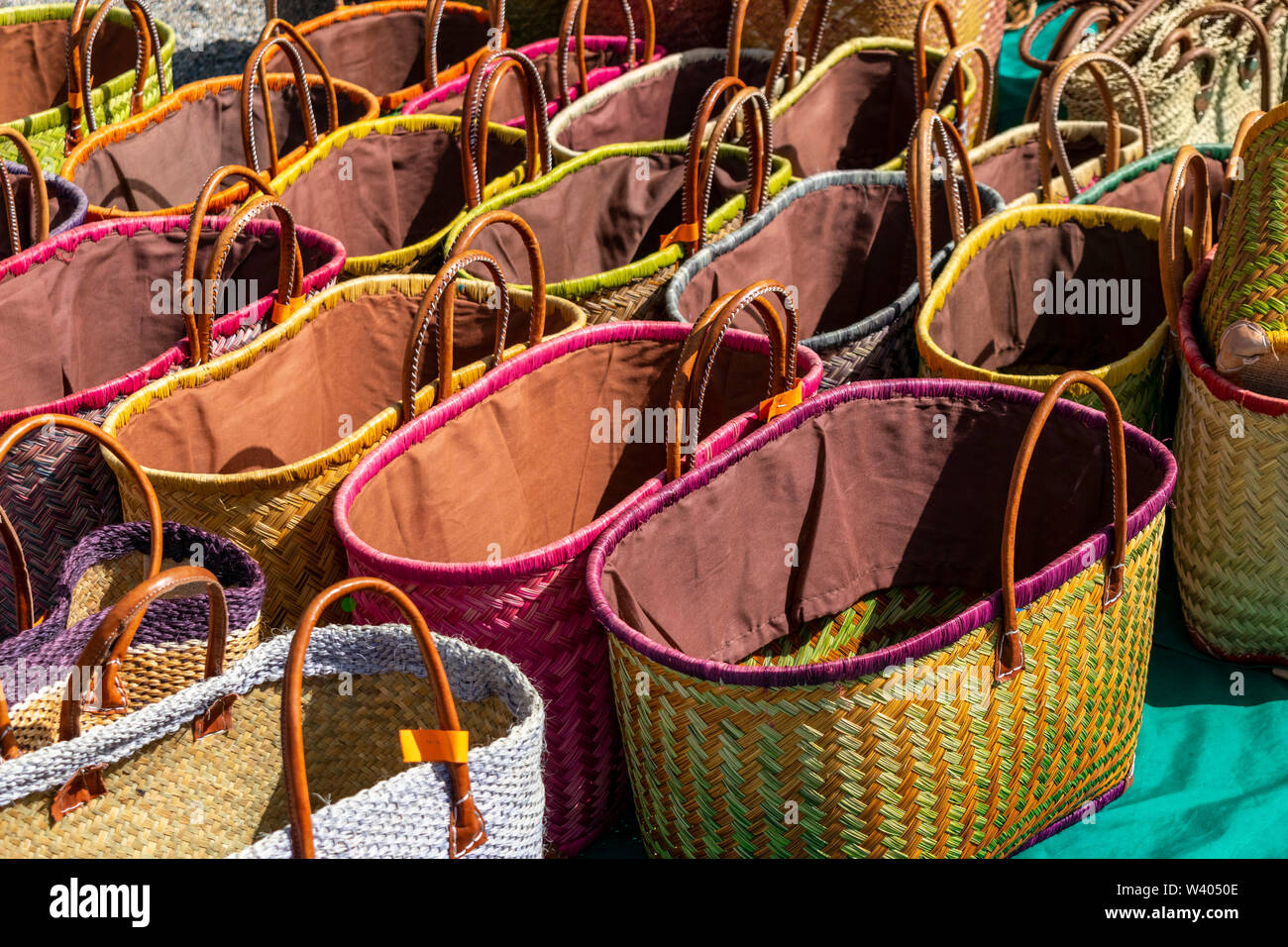 A display of colourful handmade wicker baskets for sale in a French