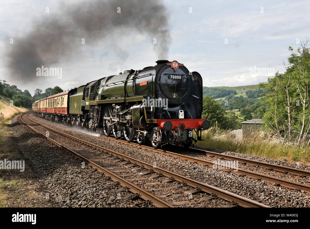 Locomotive 'Britannia' steams northward up the gradient of the Settle-Carlisle railway line with 'The Fellsman' special, seen at Langcliffe. Stock Photo