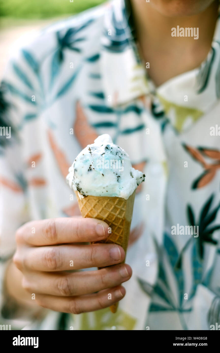 Close up hand holding ice cream cone Stock Photo