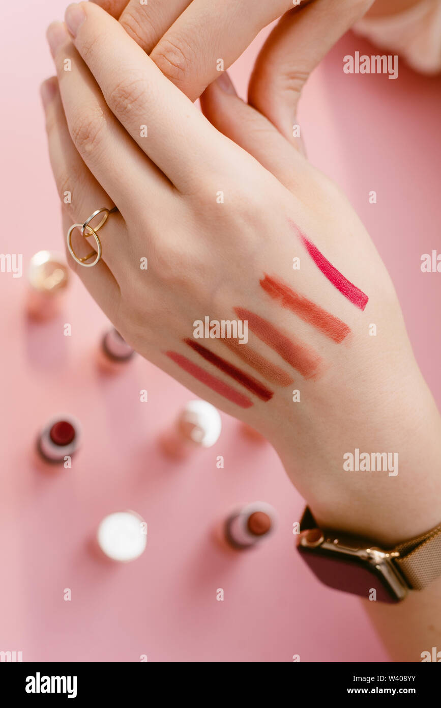Swatch lipstick on the thin hand of a girl. Swatches of different