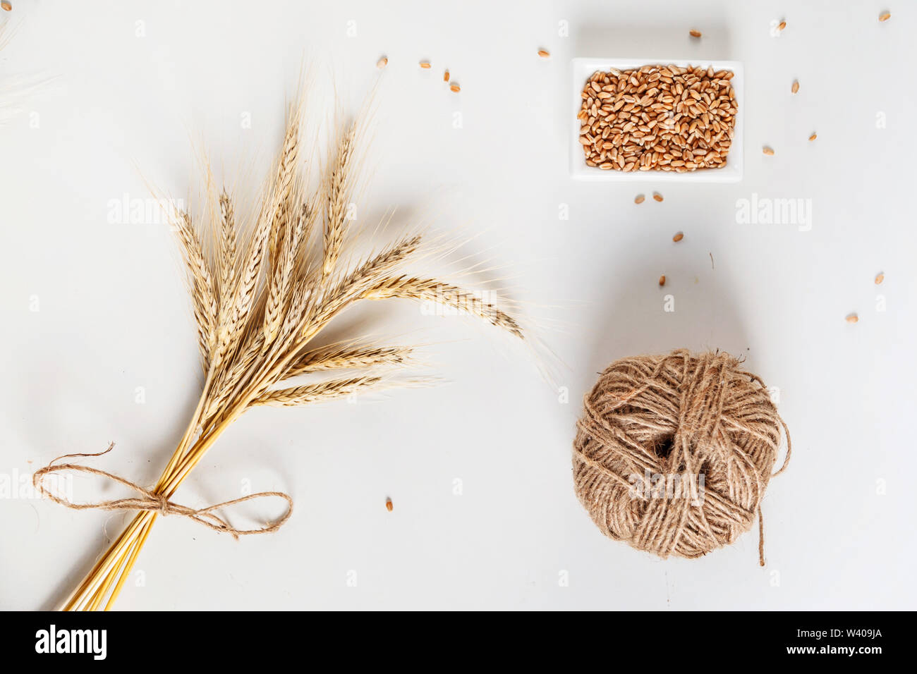 wheat ears and bowl of grains on white background, flat lay Stock Photo ...