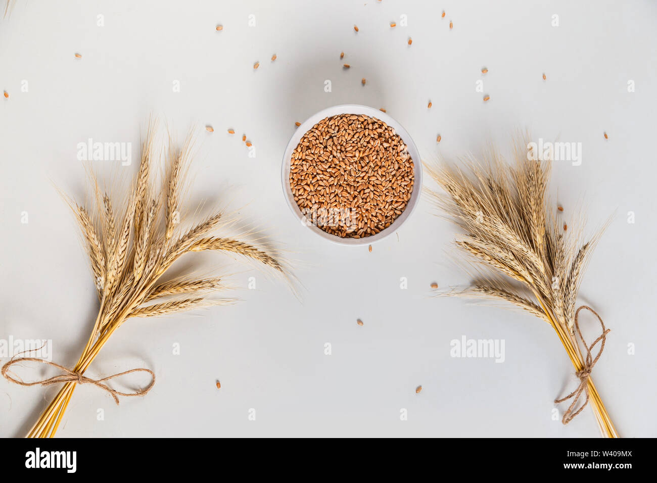 wheat ears and bowl of grains on a white background, flat lay Stock ...