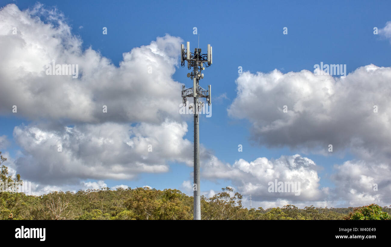 Cellular, mobile phone transmitter tower with blue sky and clouds Stock Photo