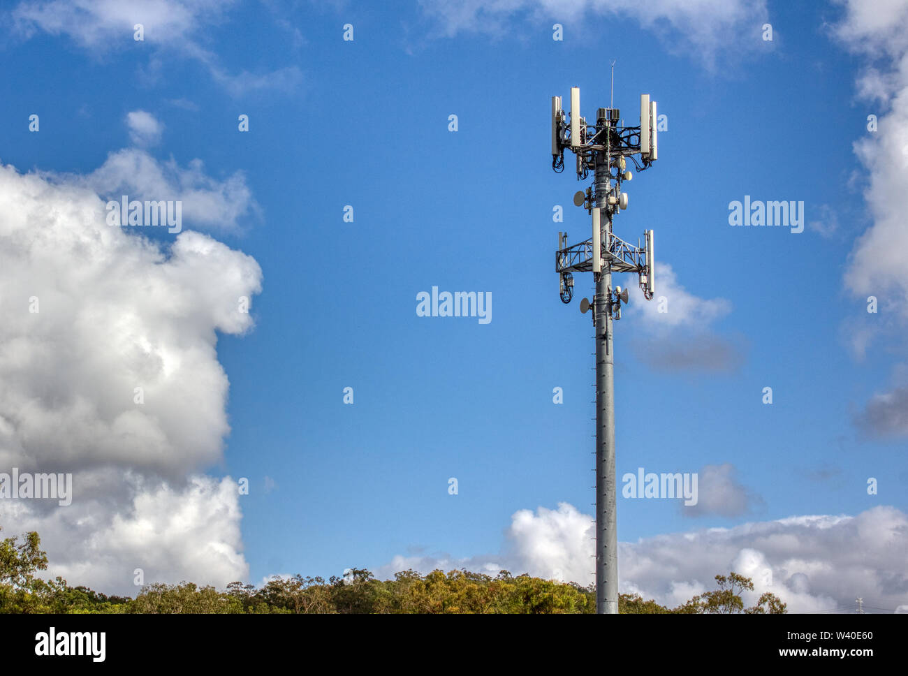Cellular, mobile phone transmitter tower with blue sky and clouds right Stock Photo