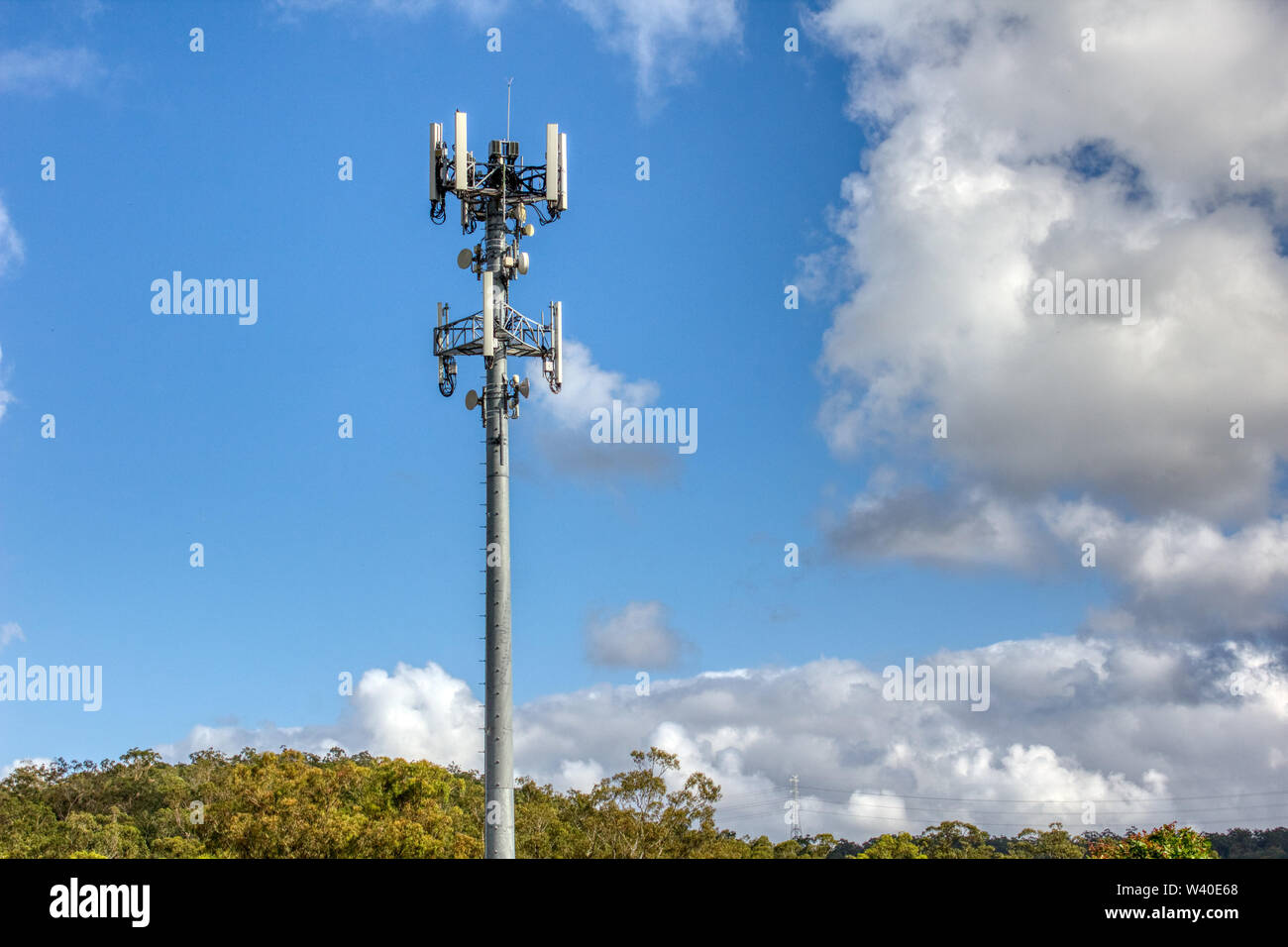 Cellular, mobile phone transmitter tower with blue sky and clouds left Stock Photo