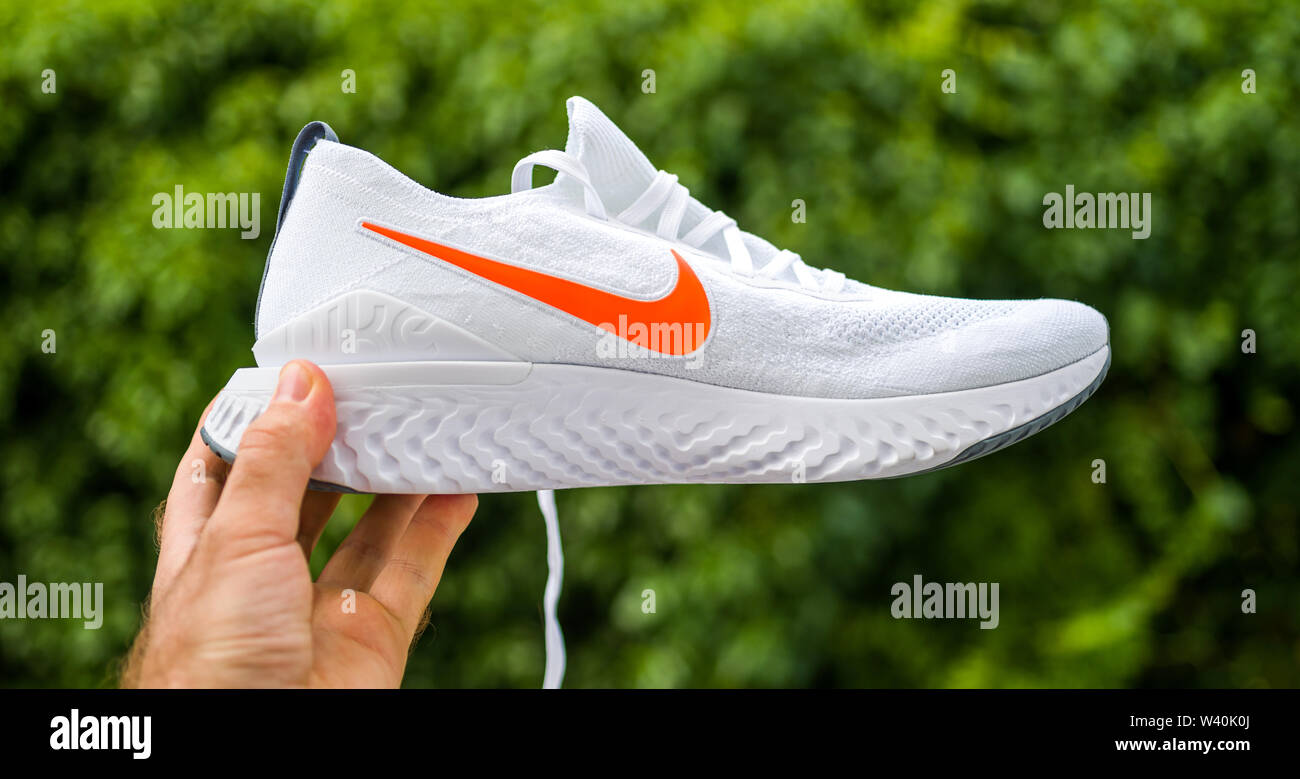 Paris, France - Jul 8, 2019: Athlete man hand holding presenting new  running shoes Nike Epic React Flyknit 2 side view with red logotype Stock  Photo - Alamy