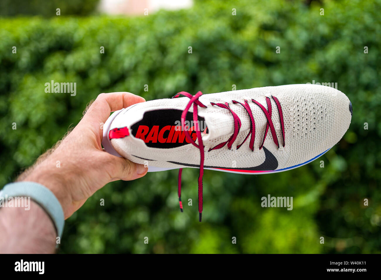 Paris, France - Jul 8, 2019: Athlete man hand holding presenting new running  shoes Nike Zoom Fly Flyknit against green background - view from above of  the shoe Stock Photo - Alamy