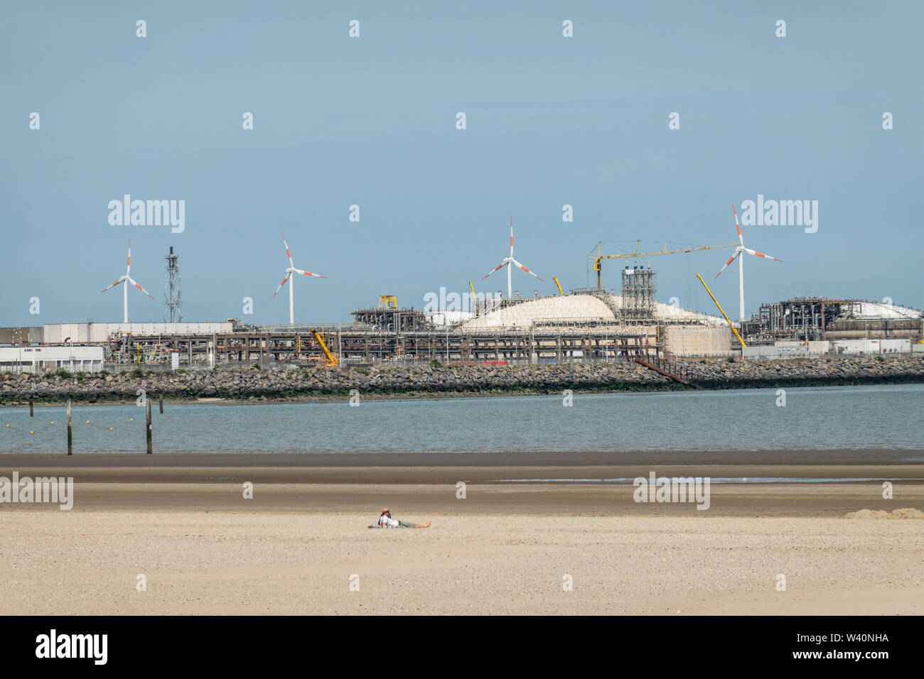Zeebrugge, Flanders, Belgium -  June 18, 2019: Closeup of LNG terminal in port of Zeebrugge under blue sky as seen from beach in Knokke-Heist. Lone su Stock Photo