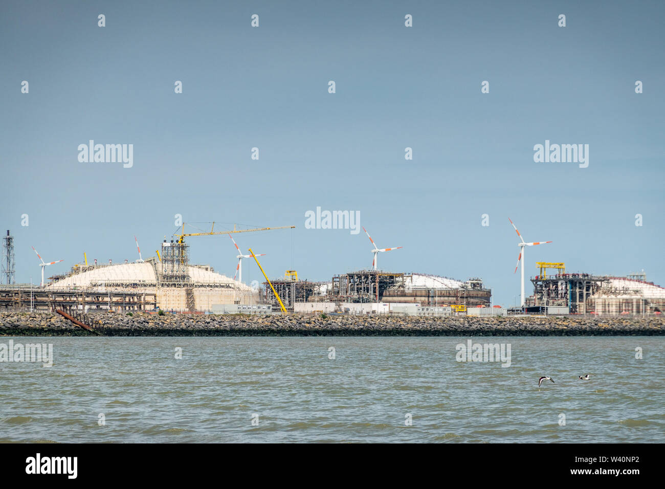 Zeebrugge, Flanders, Belgium -  June 18, 2019: Closeup of LNG terminal in port of Zeebrugge under blue sky as seen from beach in Knokke-Heist. Stock Photo