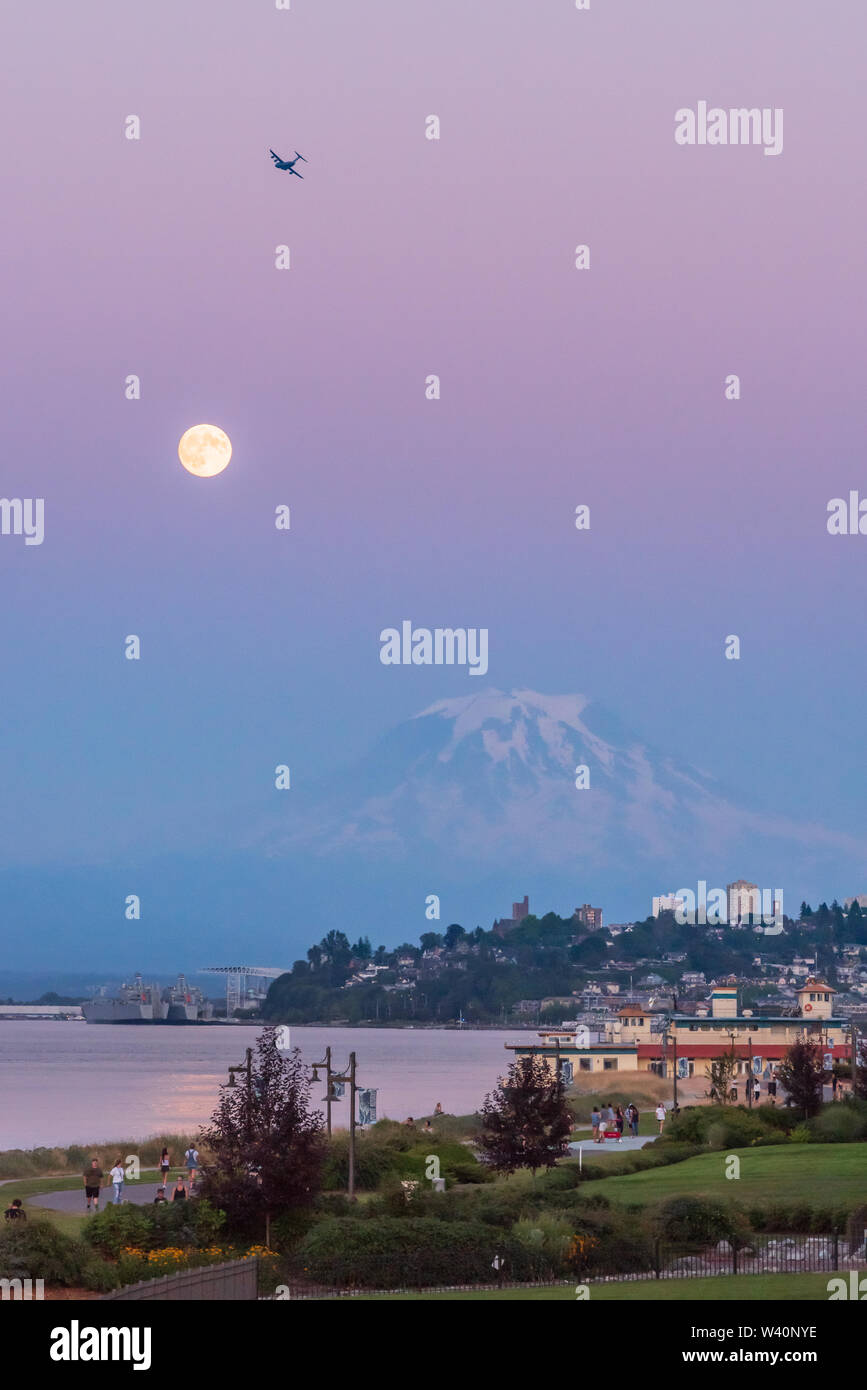 Mt Rainier Hovers Over Downtown Tacoma and Commencement Bay as Seen from Point Ruston with people walking Stock Photo