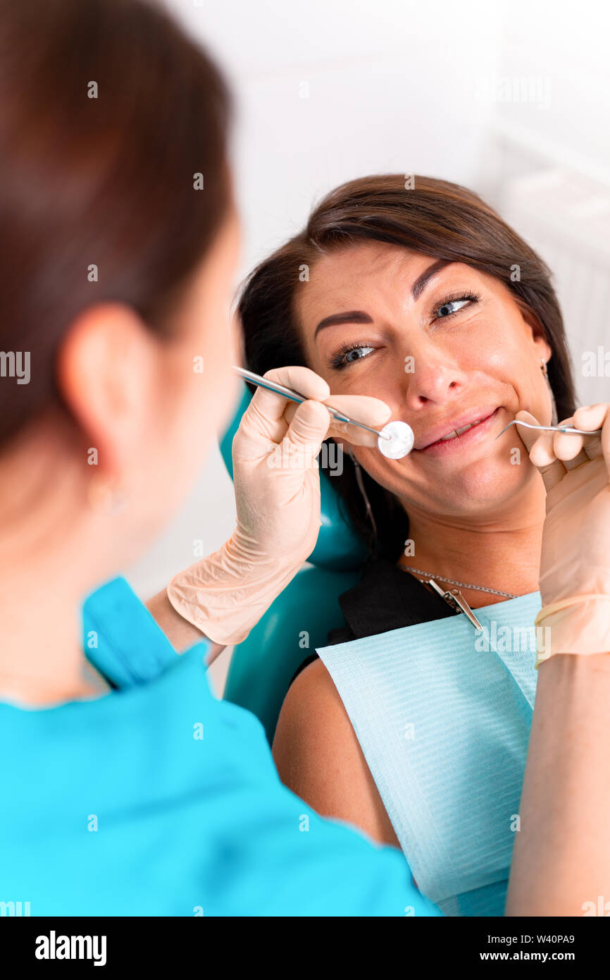 Putting dental braces to the woman's teeth at the dental office