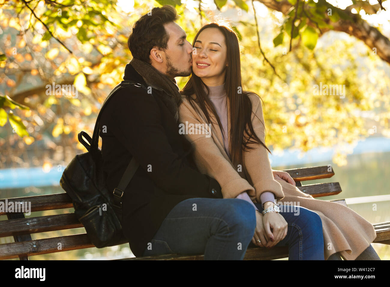 Young couple kissing on park bench hi-res stock photography and images ...