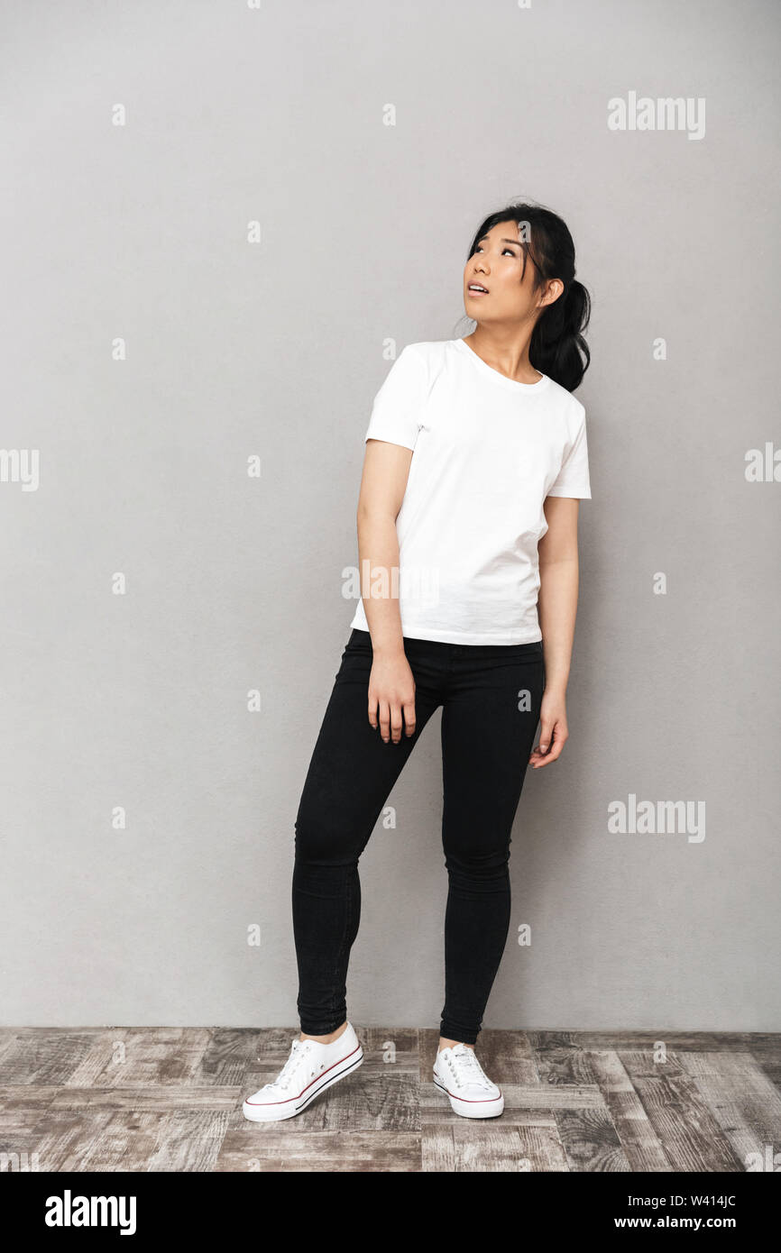 Image of asian beautiful young woman posing isolated over grey wall ...