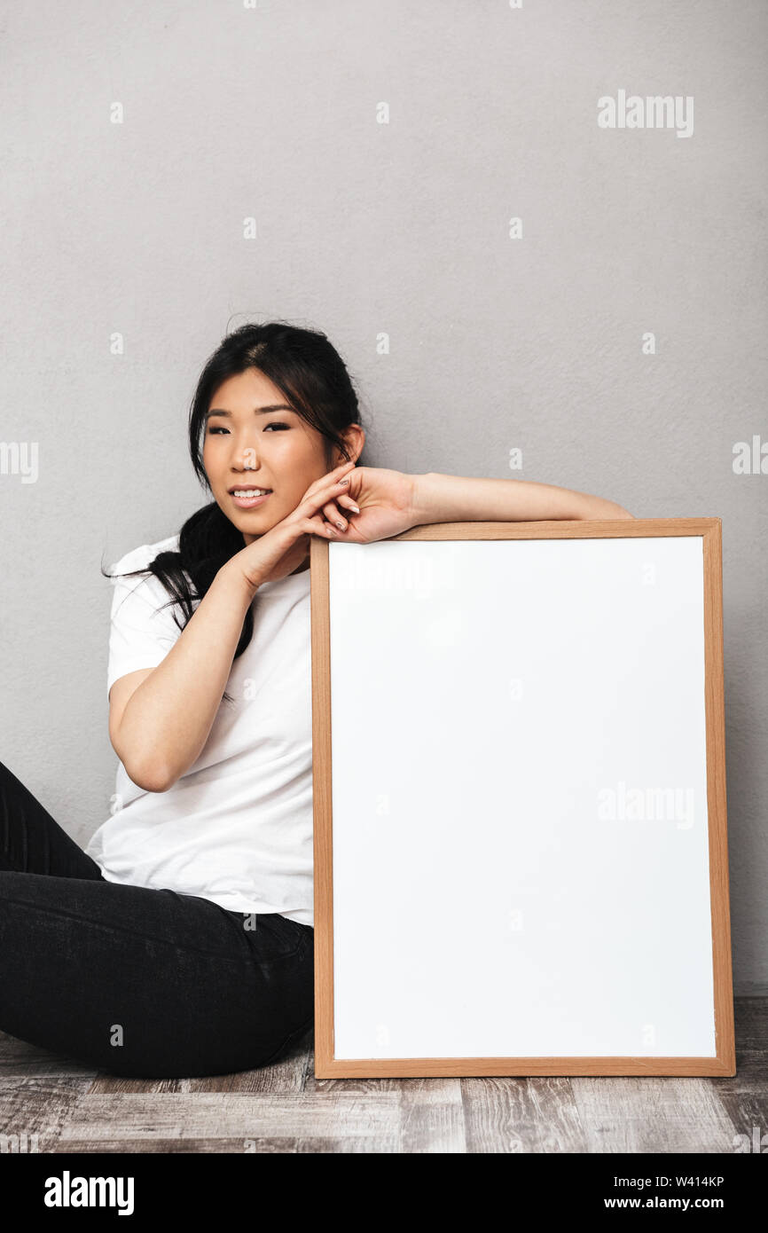 Image of asian beautiful young woman posing isolated over grey wall ...