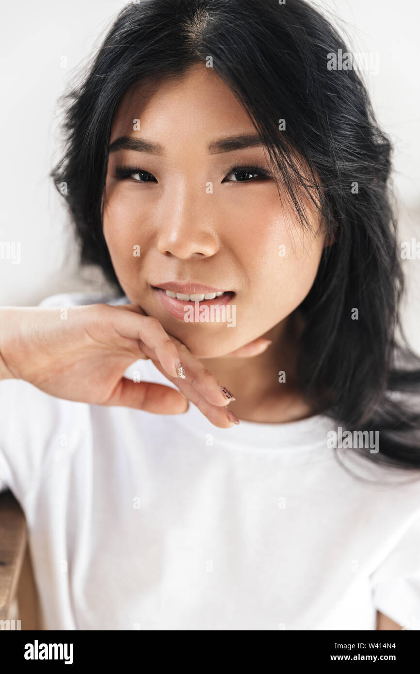 Image of asian beautiful young woman posing isolated over white wall ...