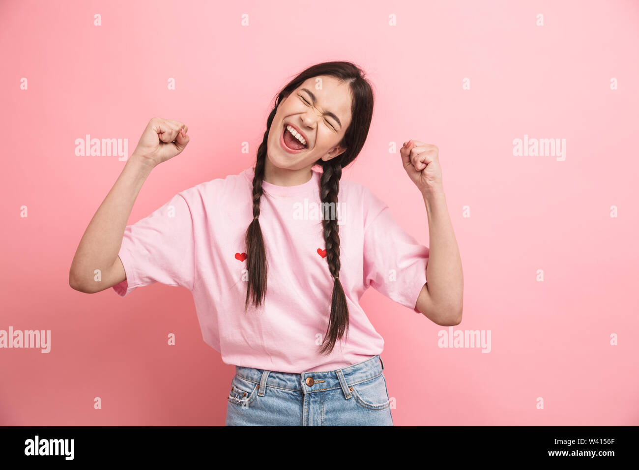 Image of happy attractive girl with two braids smiling and rejoicing at ...