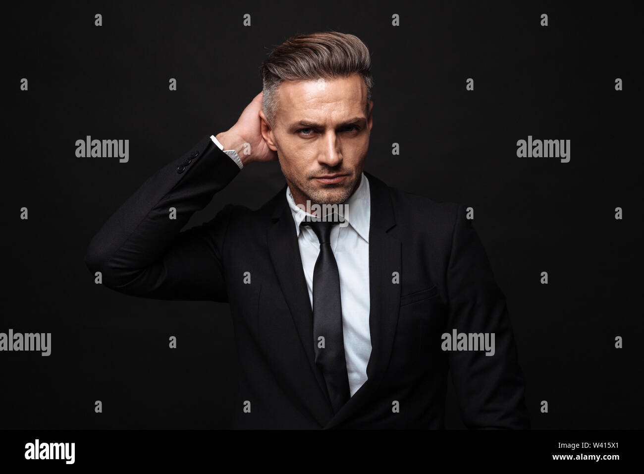Portrait of handsome businessman dressed in formal suit posing and ...