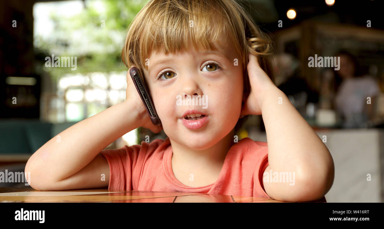 Cheerful toddler speaking on mobile phone Stock Photo