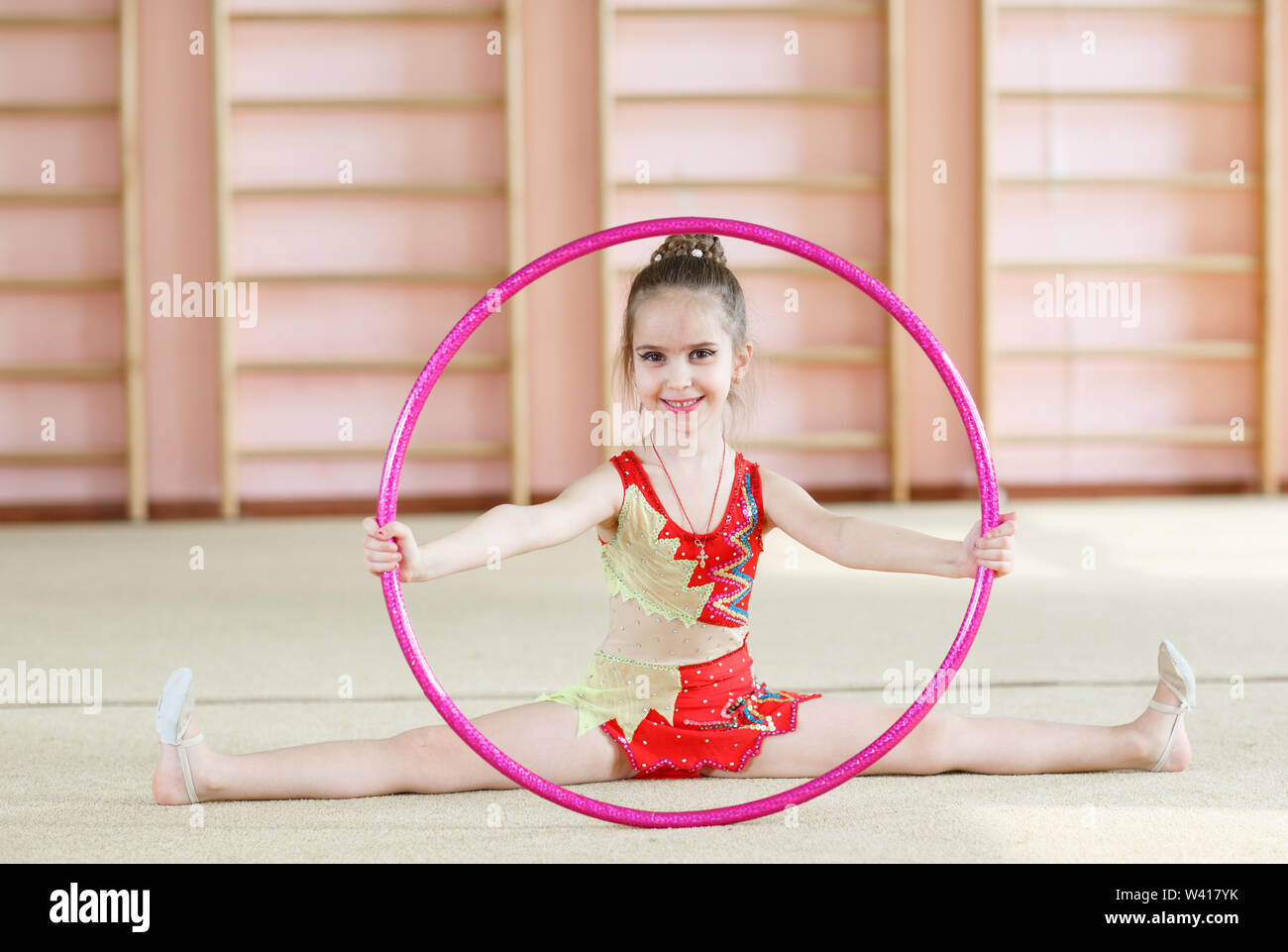 Little girl in pink clothes with hula hoop doing gymnastics, isolated on  white Stock Photo - Alamy