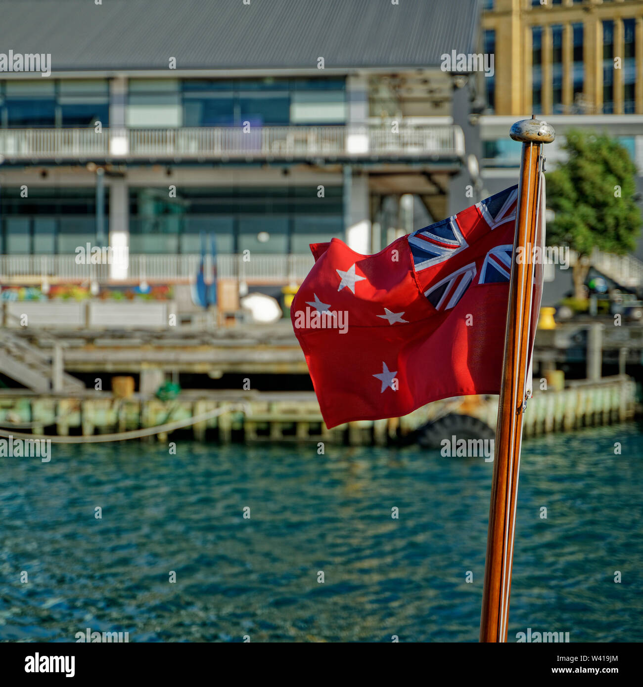 Wellington, Wellington/New Zealand - May 25, 2019: New Zealand Red Ensign fluttering in a breeze in Wellington harbour, New Zealand. Stock Photo