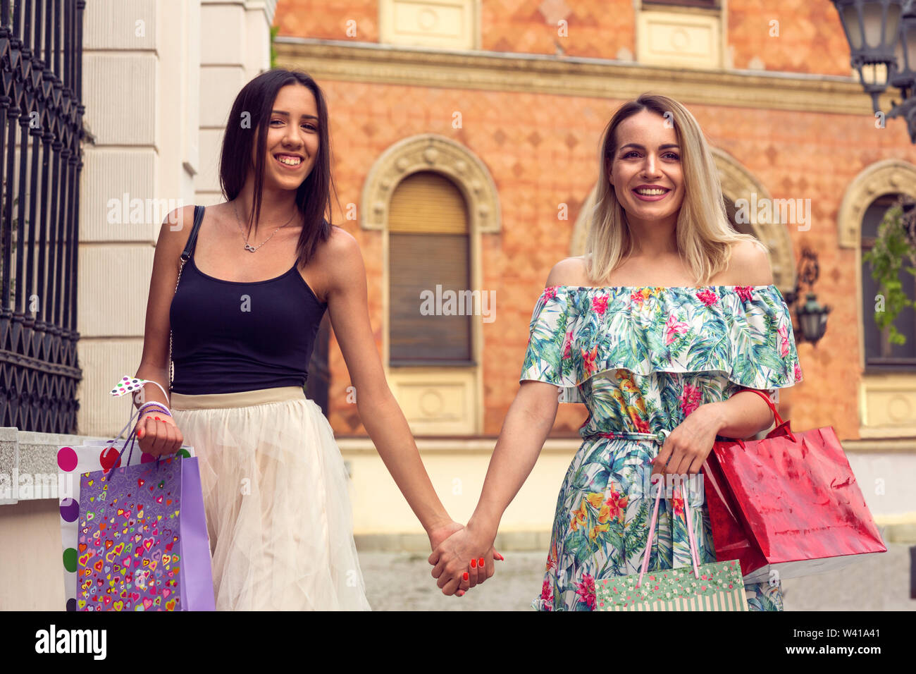 Happiness, friends, sale and fun concept-smiling young women with shopping bags. Stock Photo