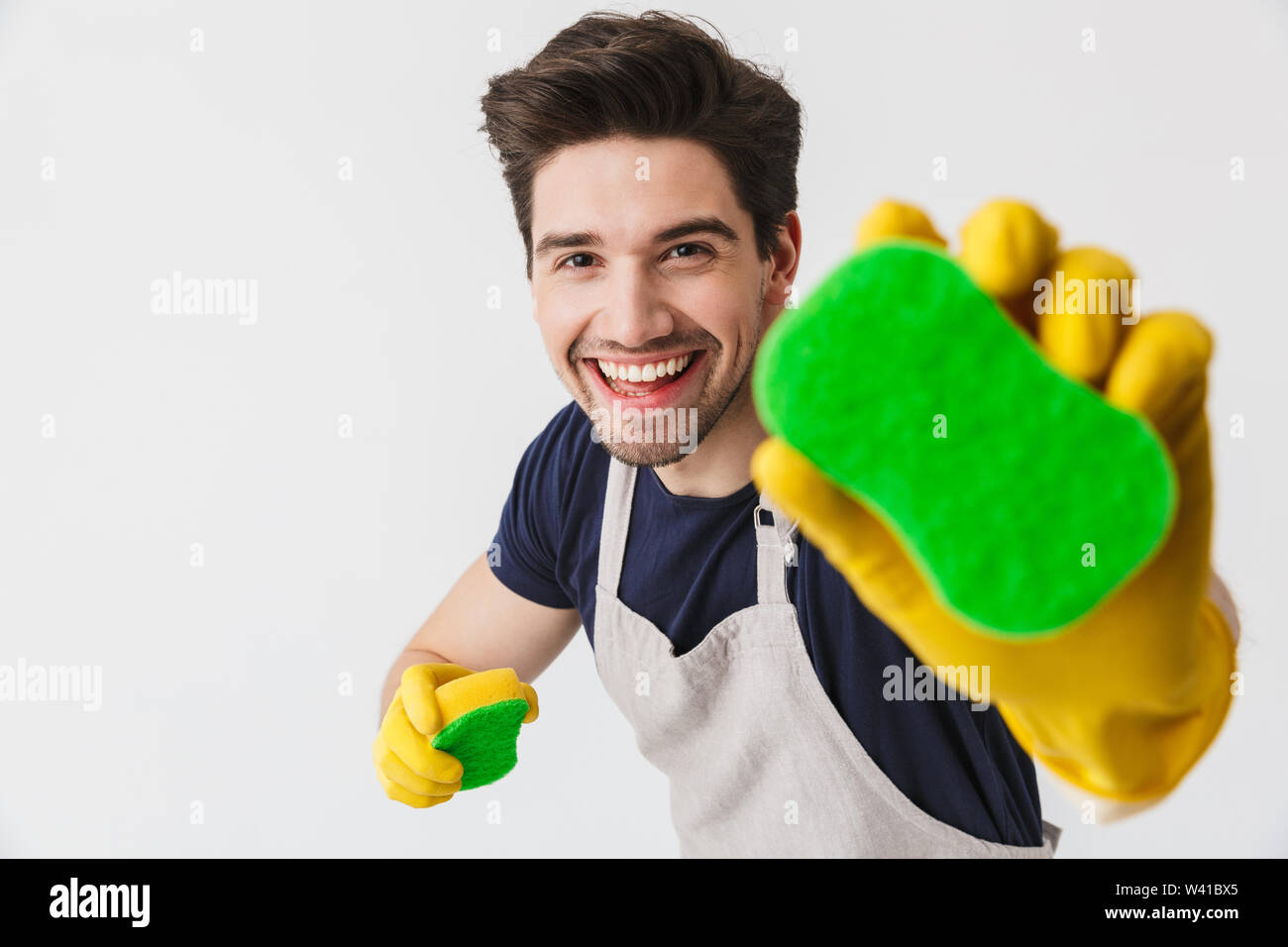 Photo of optimistic young man wearing yellow rubber gloves for hands ...