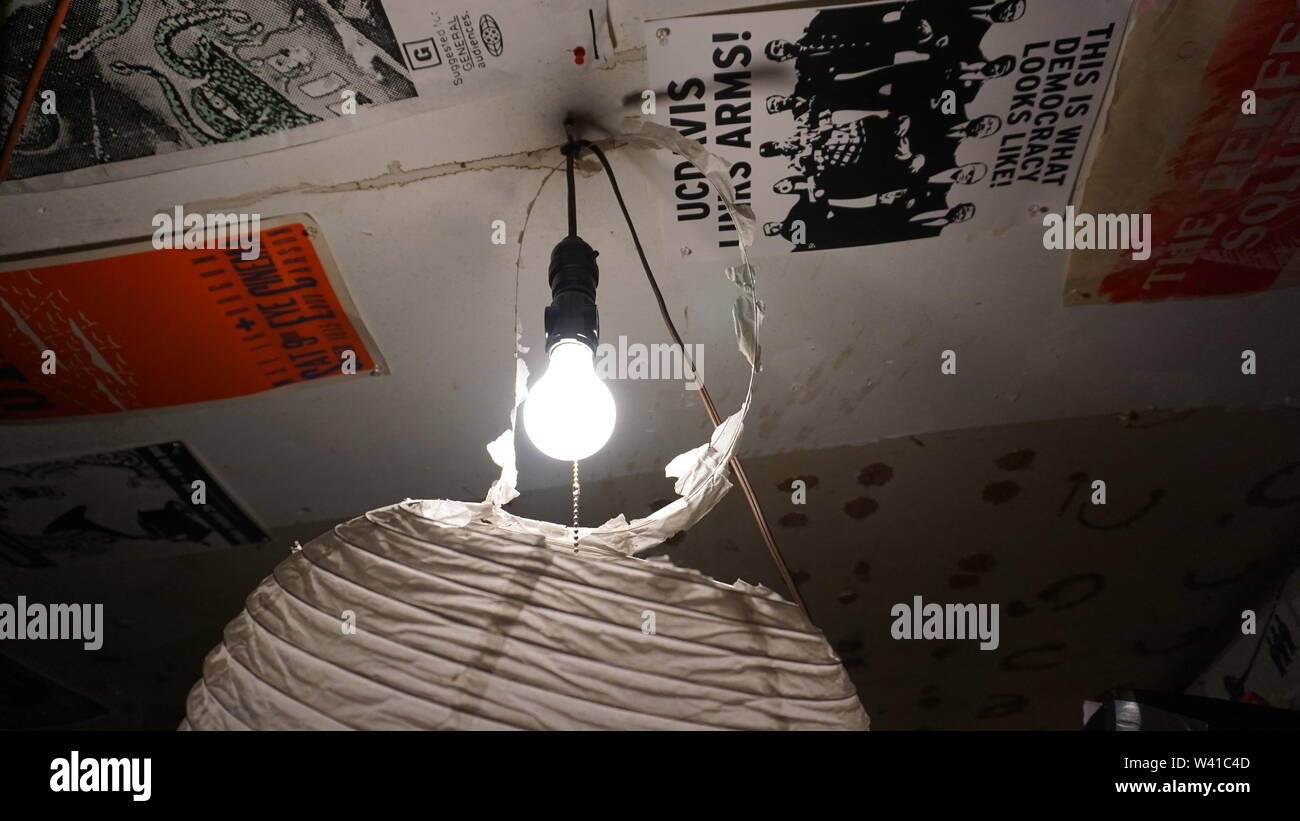 Basement studio of underground, experimental filmmaker Craig Baldwin. Mission District, San Francisco, California. Light bulb hanging from ceiling. Stock Photo
