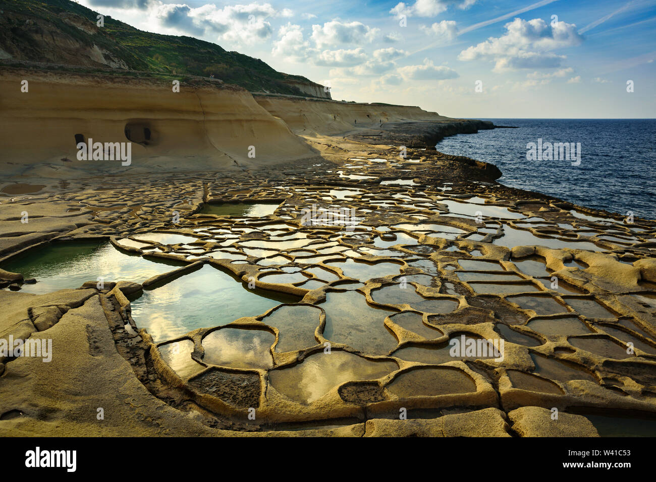 Salt evaporation pans on Malta. Ponds near sea filled with water at sunny day, february 2019 Stock Photo