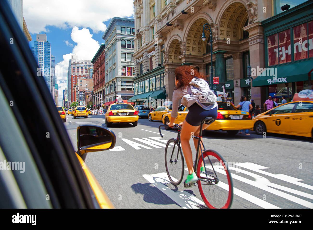 Young woman biking in Manhattan traffic Stock Photo