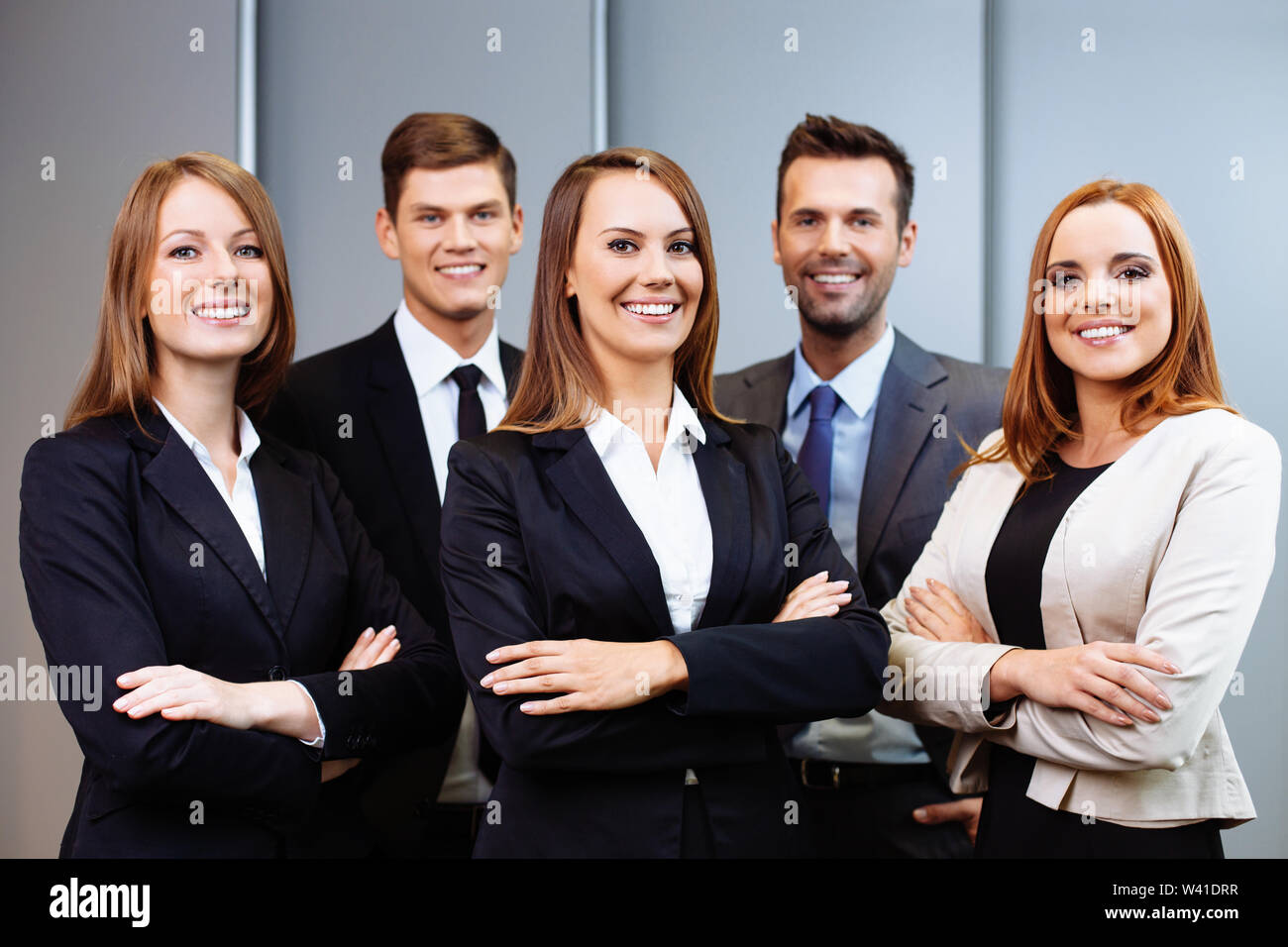 Confident business people standing with female leader Stock Photo - Alamy