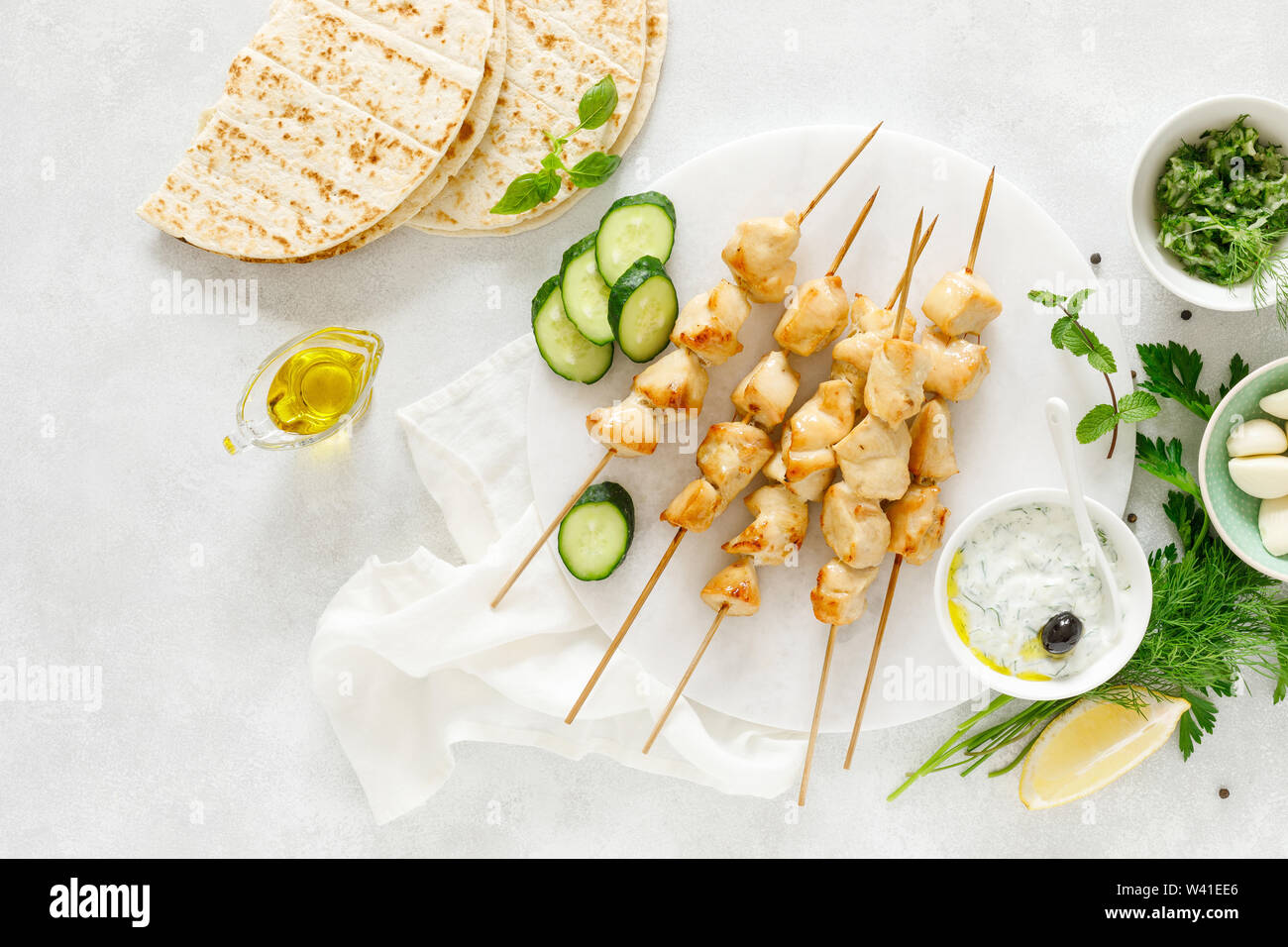 Grilled chicken kebab on skewers and traditional Greek tzatziki yogurt