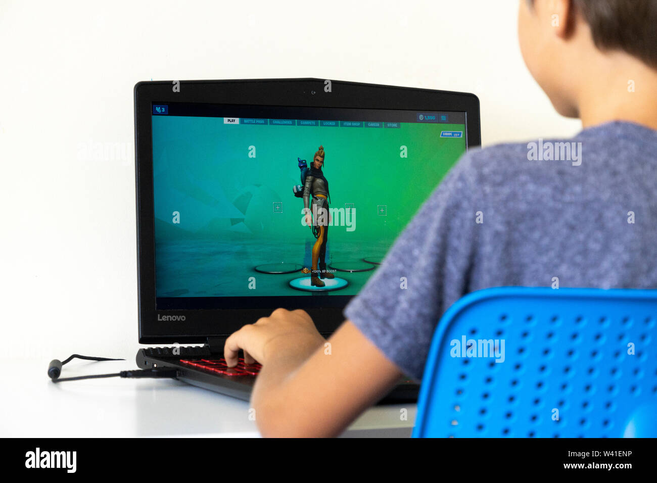 Vilnius, Lithuania - July 7, 2019: Boy playing Fortnite game on laptop computer. Fortnite is online video game developed by Epic Games Stock Photo