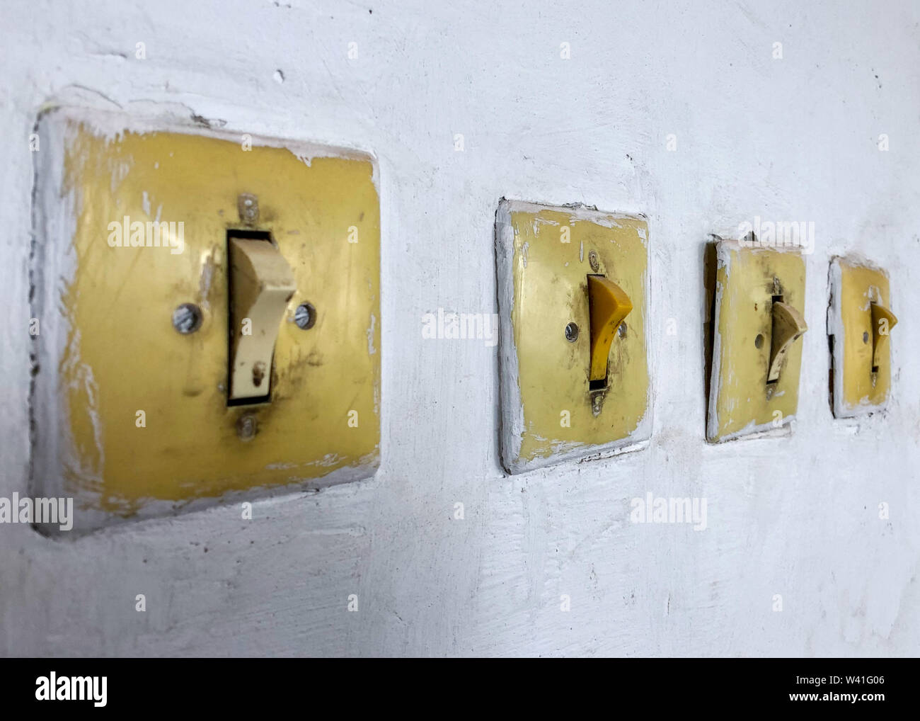 Four subjects electricians in the room. Vintage switch and light switch on the wall. Stock Photo