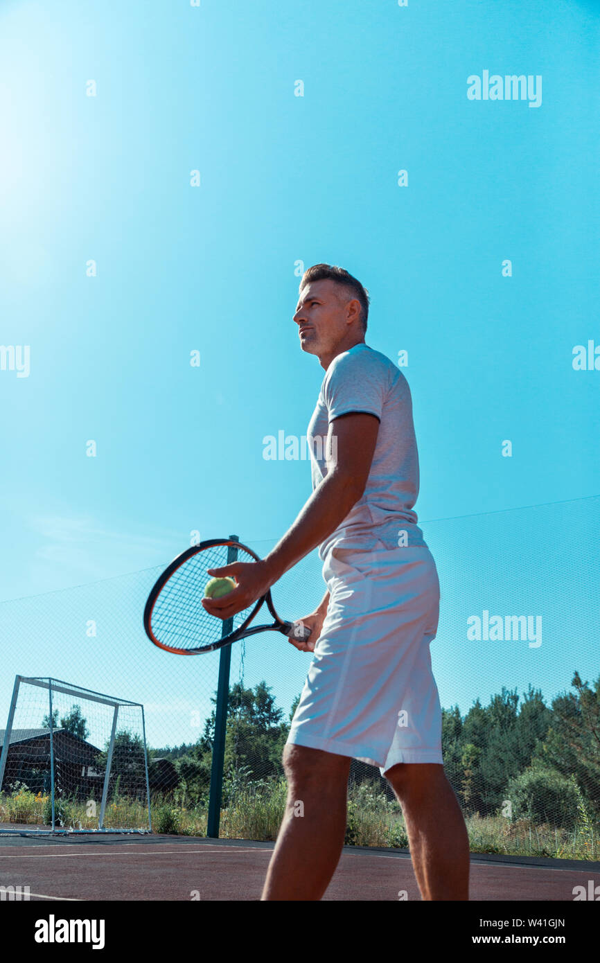 Handsome man wearing white shorts holding tennis racket Stock Photo - Alamy