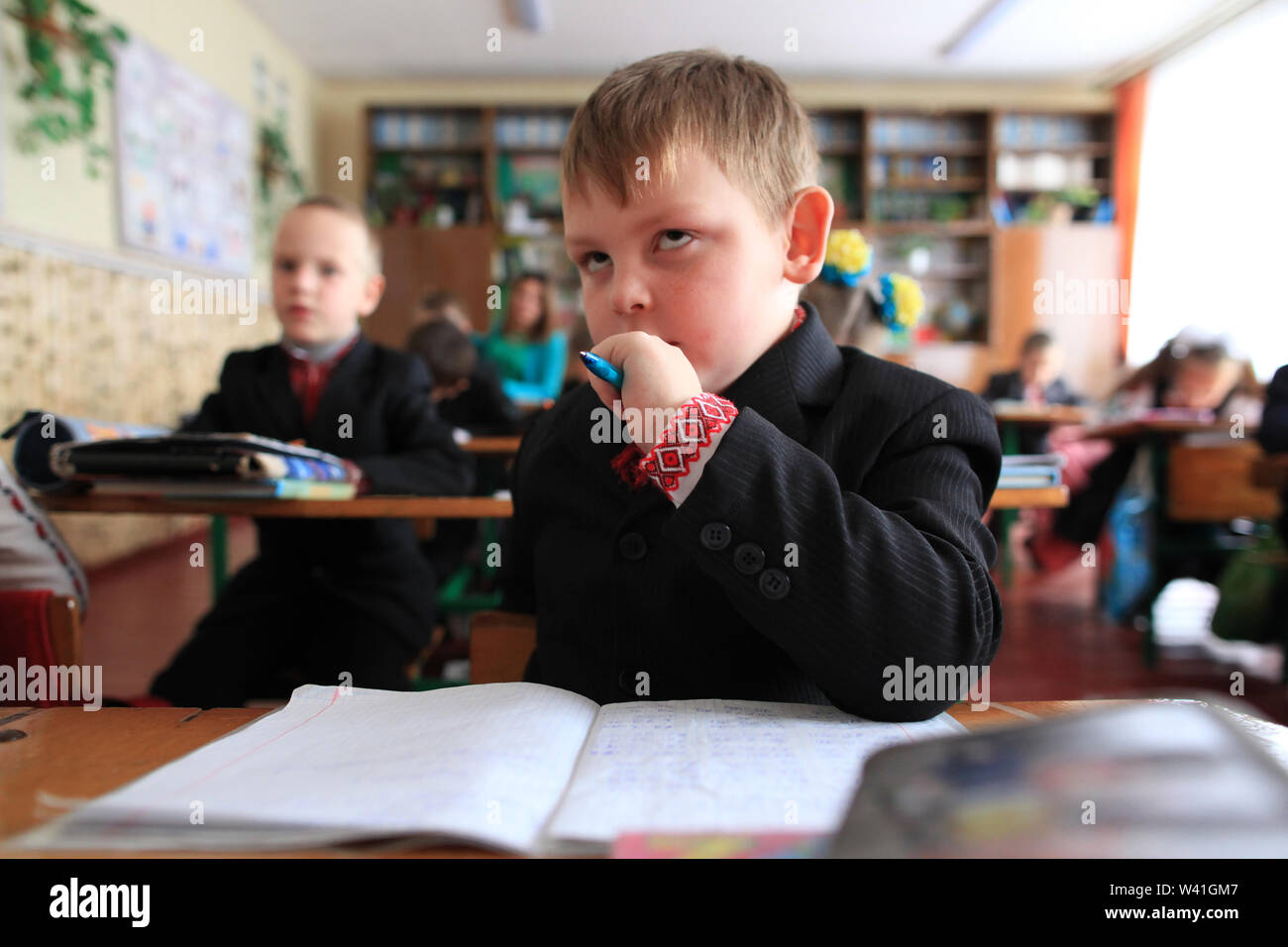 An Ukrainian schoolboy of the elementary school doing exercises during a lesson in the classroom. Radinka, Polesskiy district, Kiev Oblast, Ukraine Stock Photo