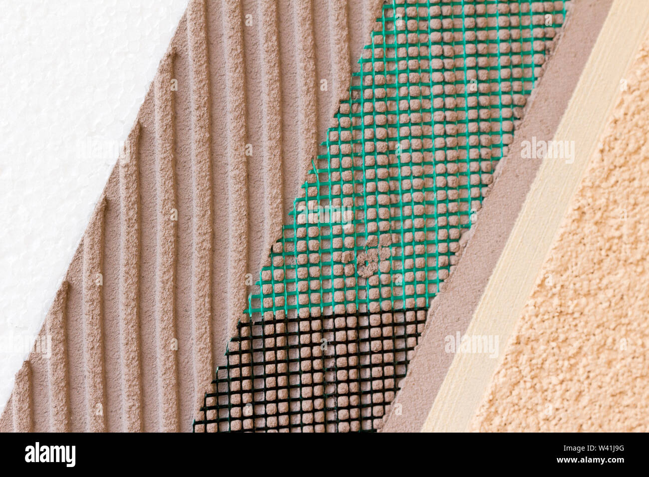 Closeup of layers on wall insulation, styrofoam mesh, plaster, cement