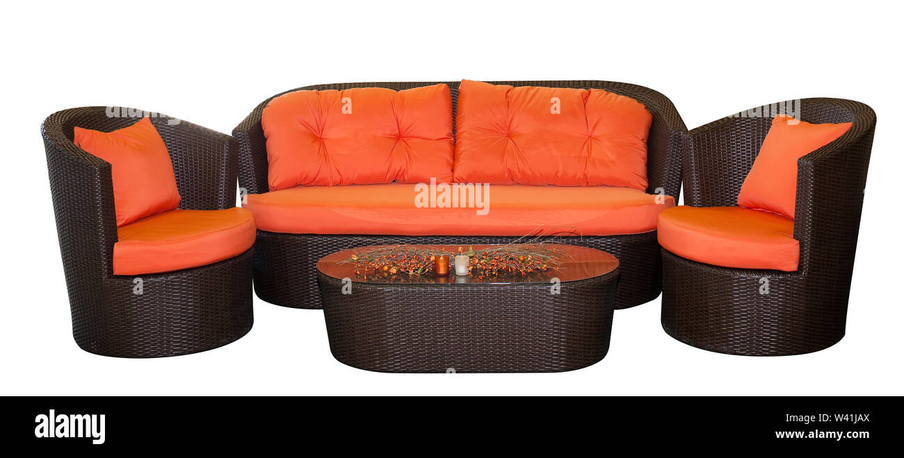 Complete set of rattan furniture with orange pillows isolated on white