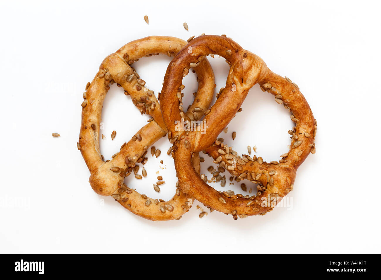 Two bavarian pretzel with sunflowers seeds isolated on white Stock