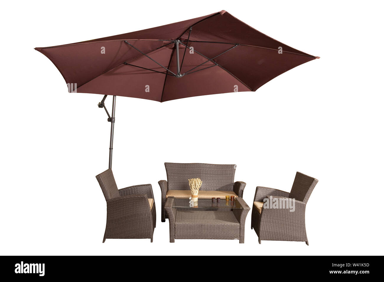 Set of rattan garden furniture under a big garden umbrella isolated on white Stock Photo