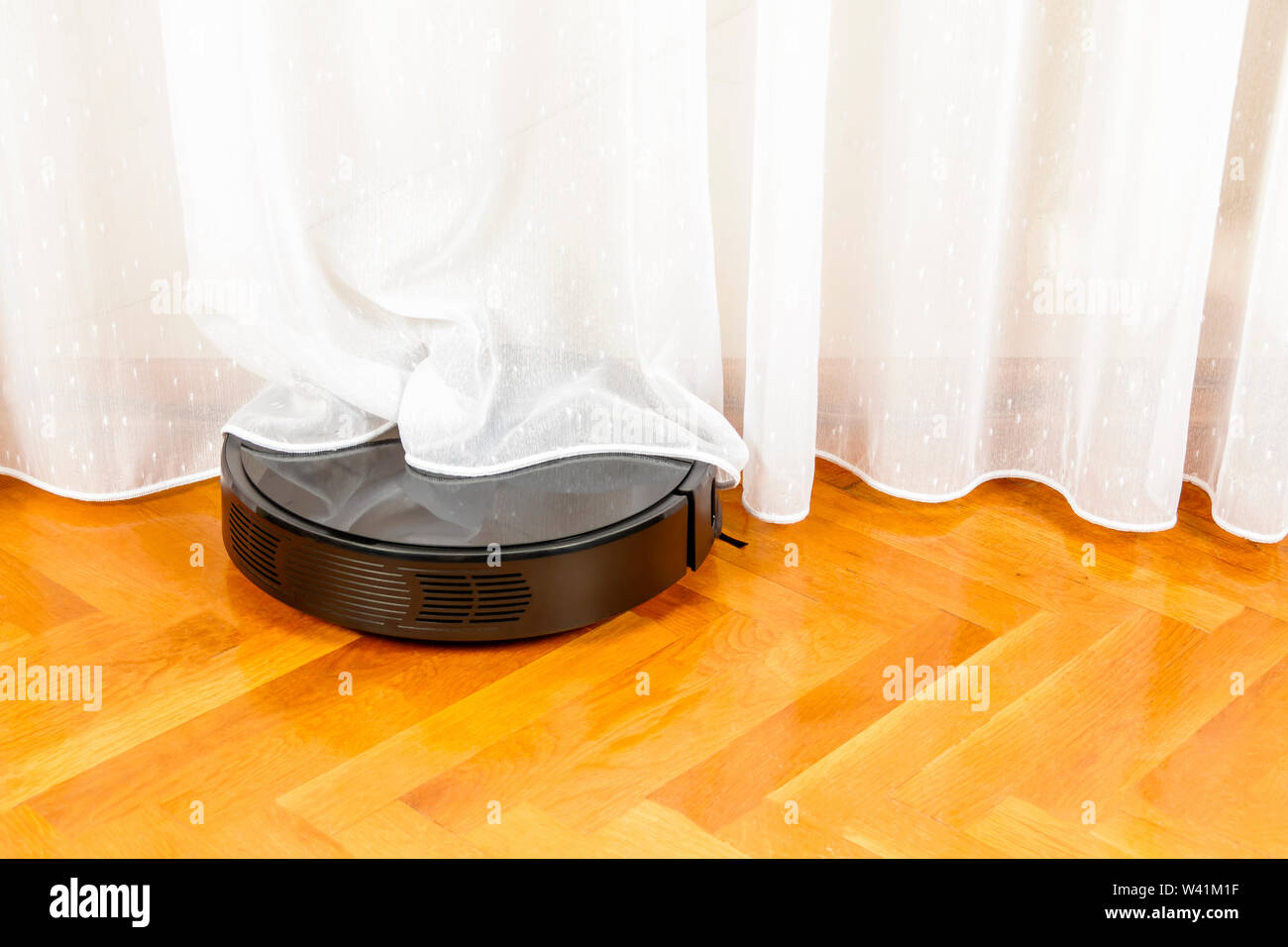 Robot vacuum cleaner tangled in window blinds Stock Photo Alamy