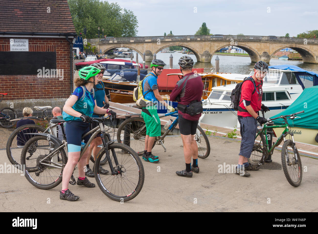 A group of mountain bikers set off from Henley-on-Thames by the bridge over the River Thames Stock Photo