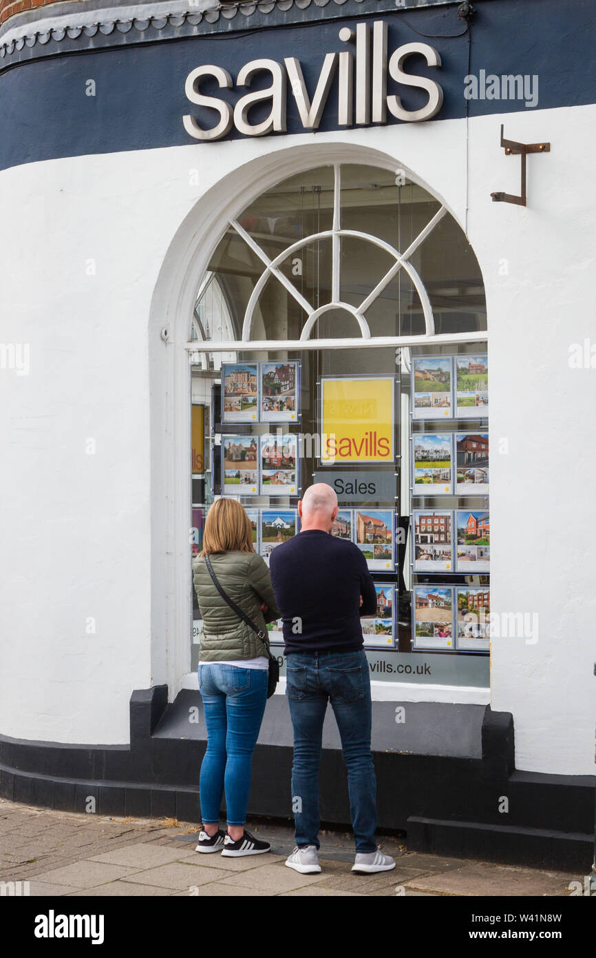 A couple look in the window of Savills estate agents in Henleyon