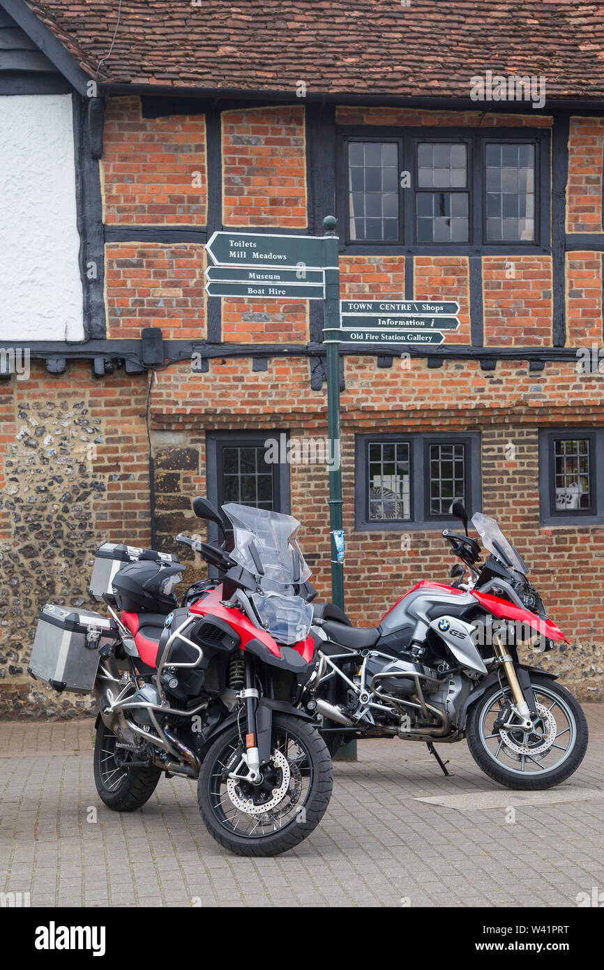 A pair of touring BMW motorcycles parked by historic houses by the River Thames at Henley-on-Thames Stock Photo