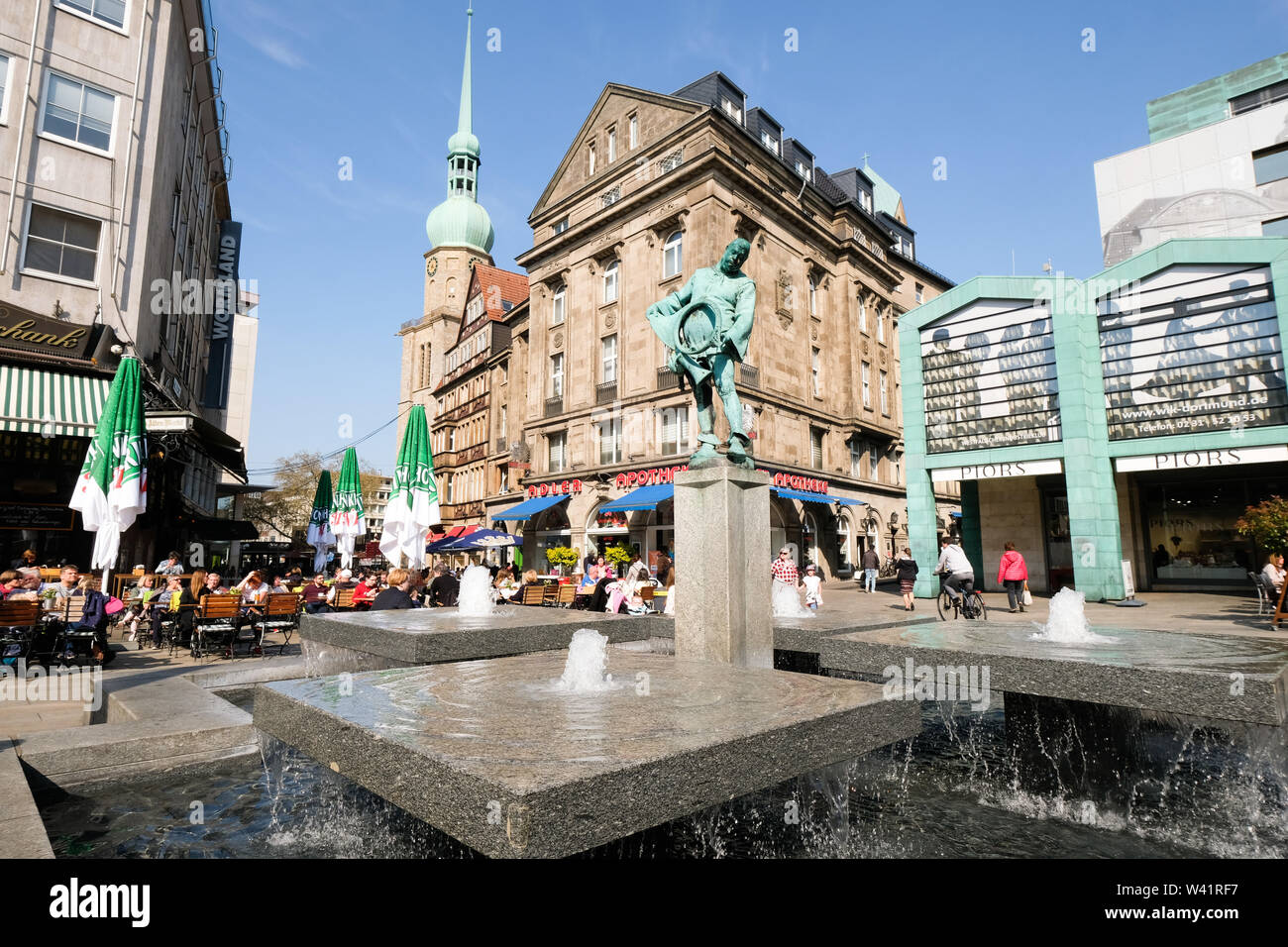 Dortmund, Germany: Blaeserbrunnen (horn blower fountain) on the 'old market place' with the Adler pharmacy and the Protestant church St. Reinoldi in the background.    ---   Dortmund: Blaeserbrunnen auf dem 'Alter Markt' mit der Adler Apotheke und der evangelischen Stadtkirche St. Reinoldi im Hintergrund. Stock Photo