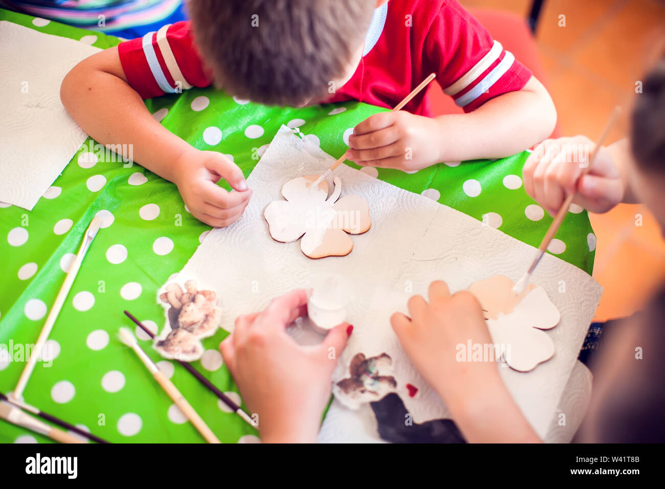 Children hands making artworks with wood and paint crafts. workplace